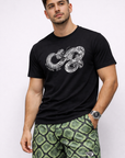 Man wearing a graphic snake t-shirt in black and RF-Wear Men's Mesh Snakeskin Shorts in Green
