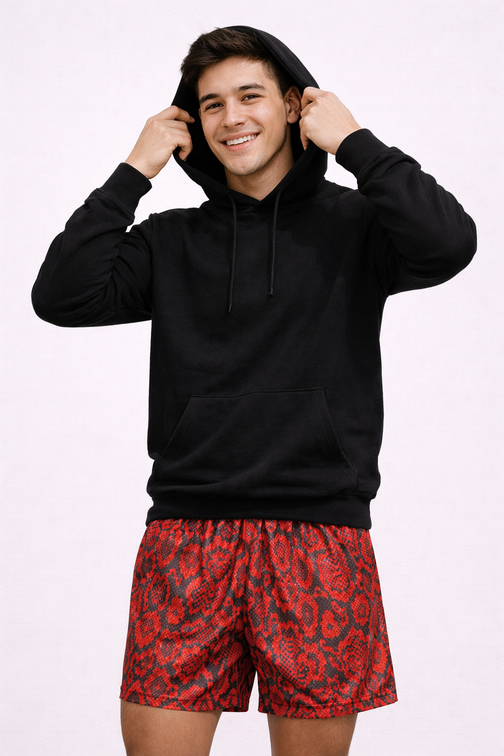 Man wearing a black hoodie and RF-Wear Men's Mesh Snakeskin Shorts in Red