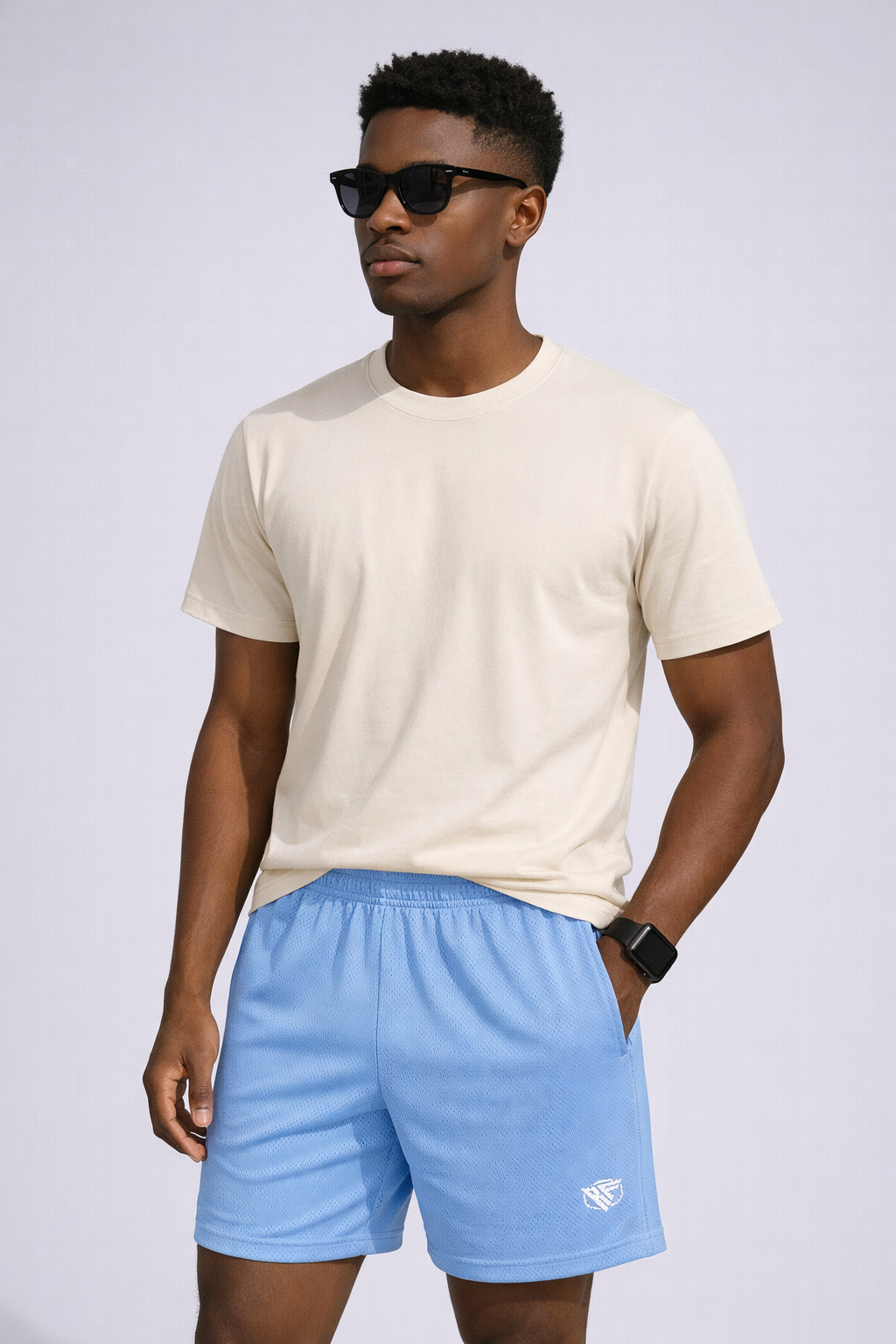 Man wearing a natural colored t-shirt and RF-Wear Men's Mesh Solid Color Shorts in Sky-Blue