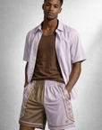 Man wearing a brown tank top and a lilac unbuttoned short sleeve dress shirt and RF-Wear Men's Mesh Split Porcelain on the Side Shorts in Pink-Lilac/Incense