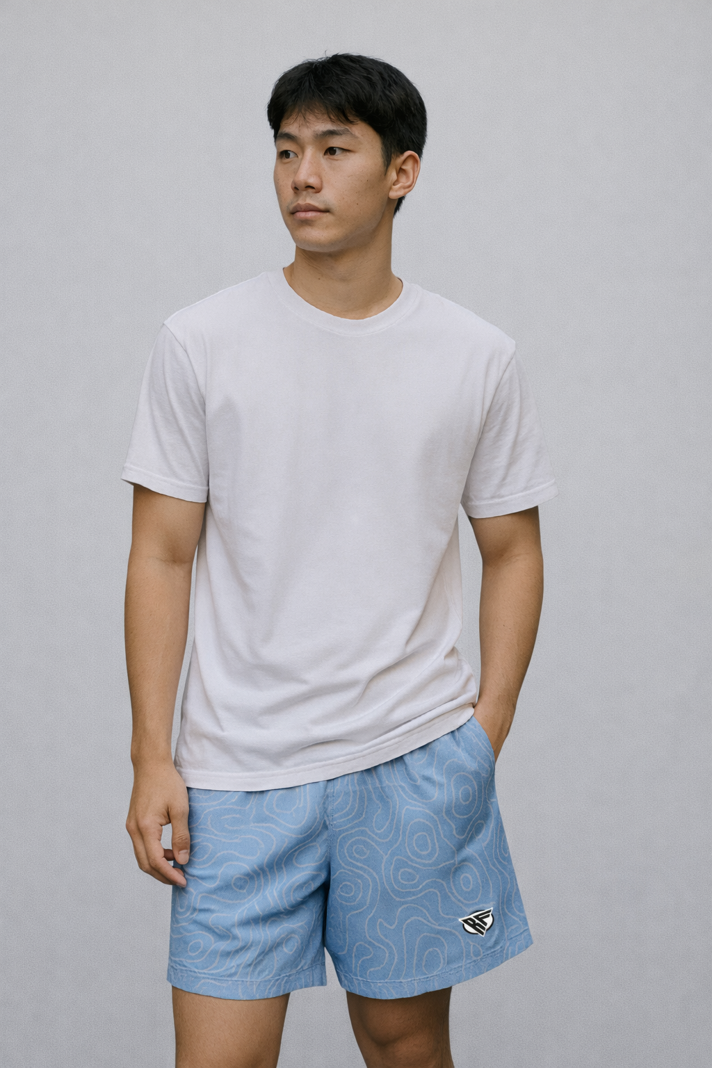 Man wearing a white top and RF-Wear Men's Mesh Topography Shorts in Sky-Blue