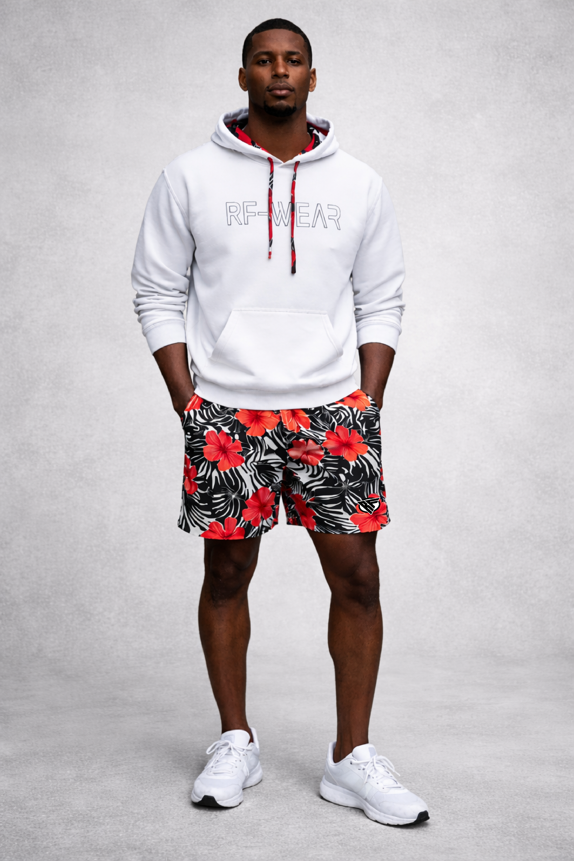 Man wearing a white RF-Wear Hoodie and RF-Wear Men's Mesh Tropical Flower Shorts in Coral on Black