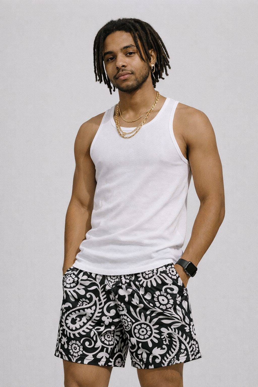 Man wearing a white tank top and RF-Wear Men's Paisley 2.0 Shorts in Black/White