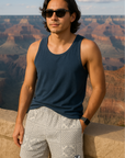 Man wearing a navy tank top and RF-Wear Men's Bandana Patchwork Shorts in Cream/Grey with Grand Canyon in background.