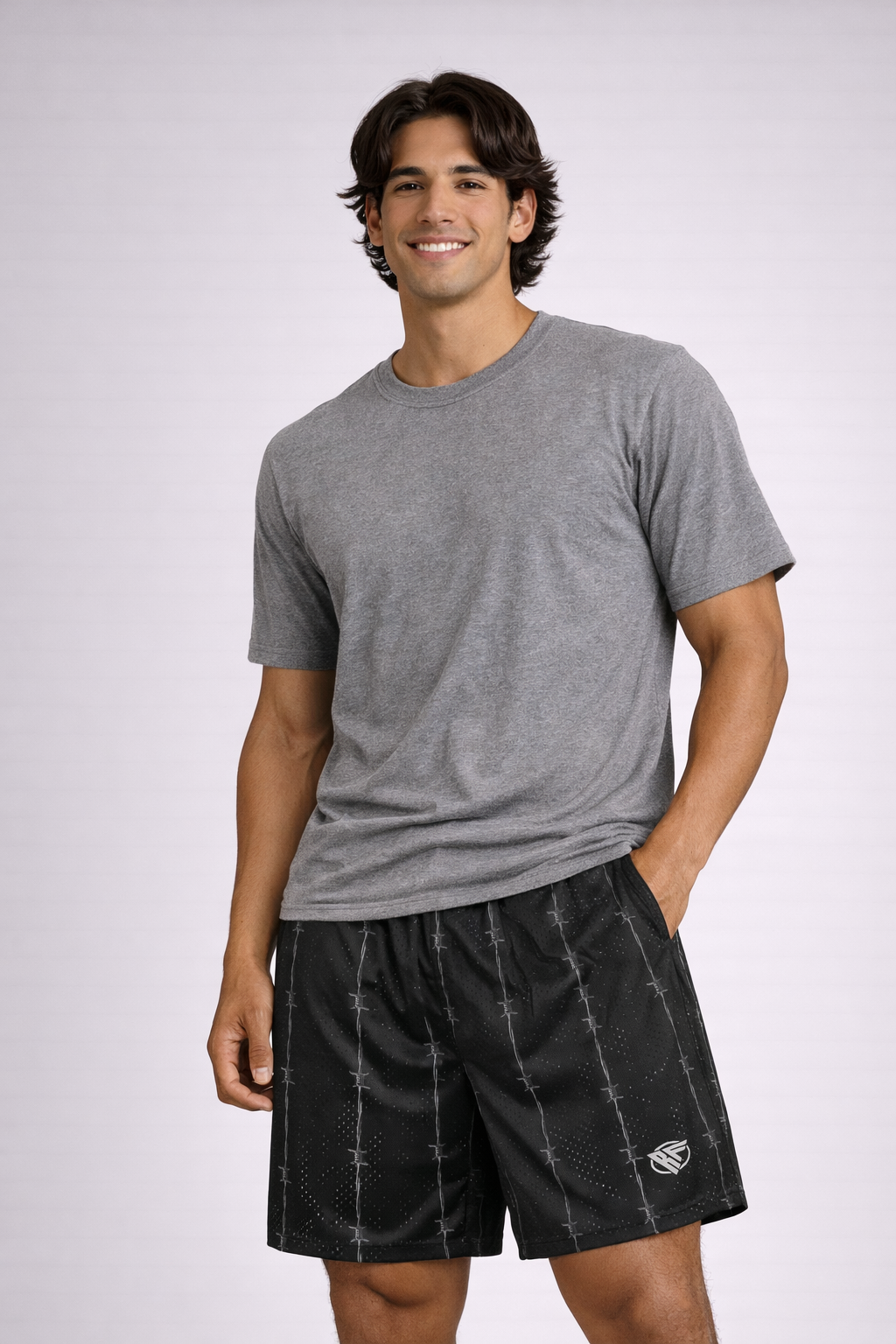 Man wearing a grey t-shirt and RF-Wear Men's Reflective Logo Barbed Wire Shorts in Black