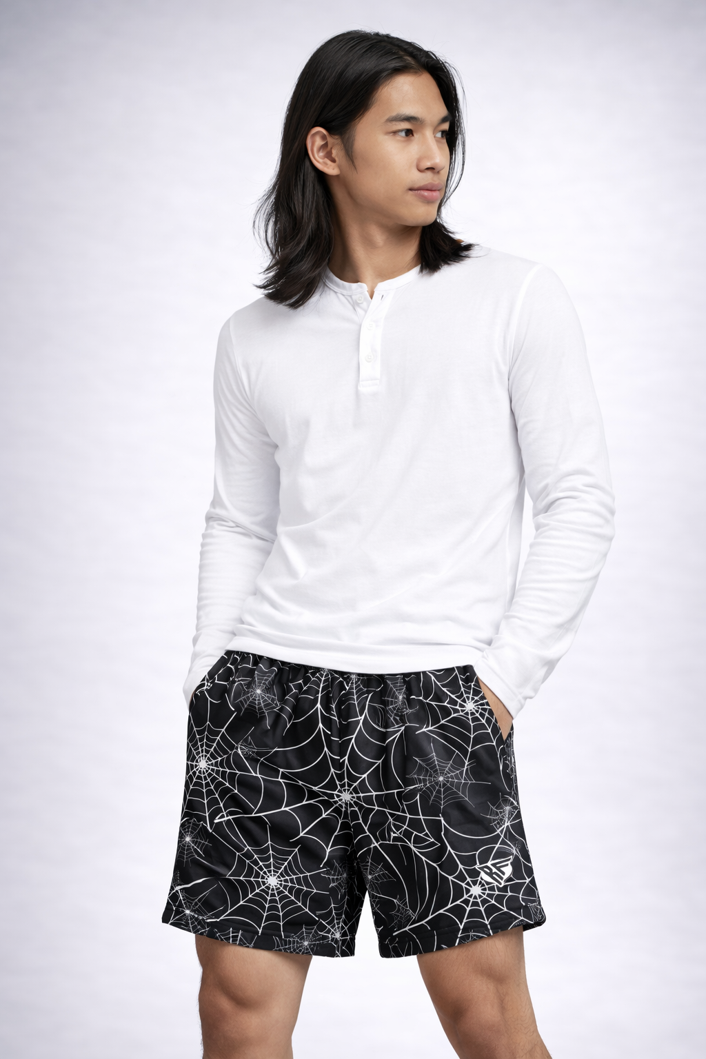 Man wearing a white top and RF-Wear men's spider Web shorts in Black