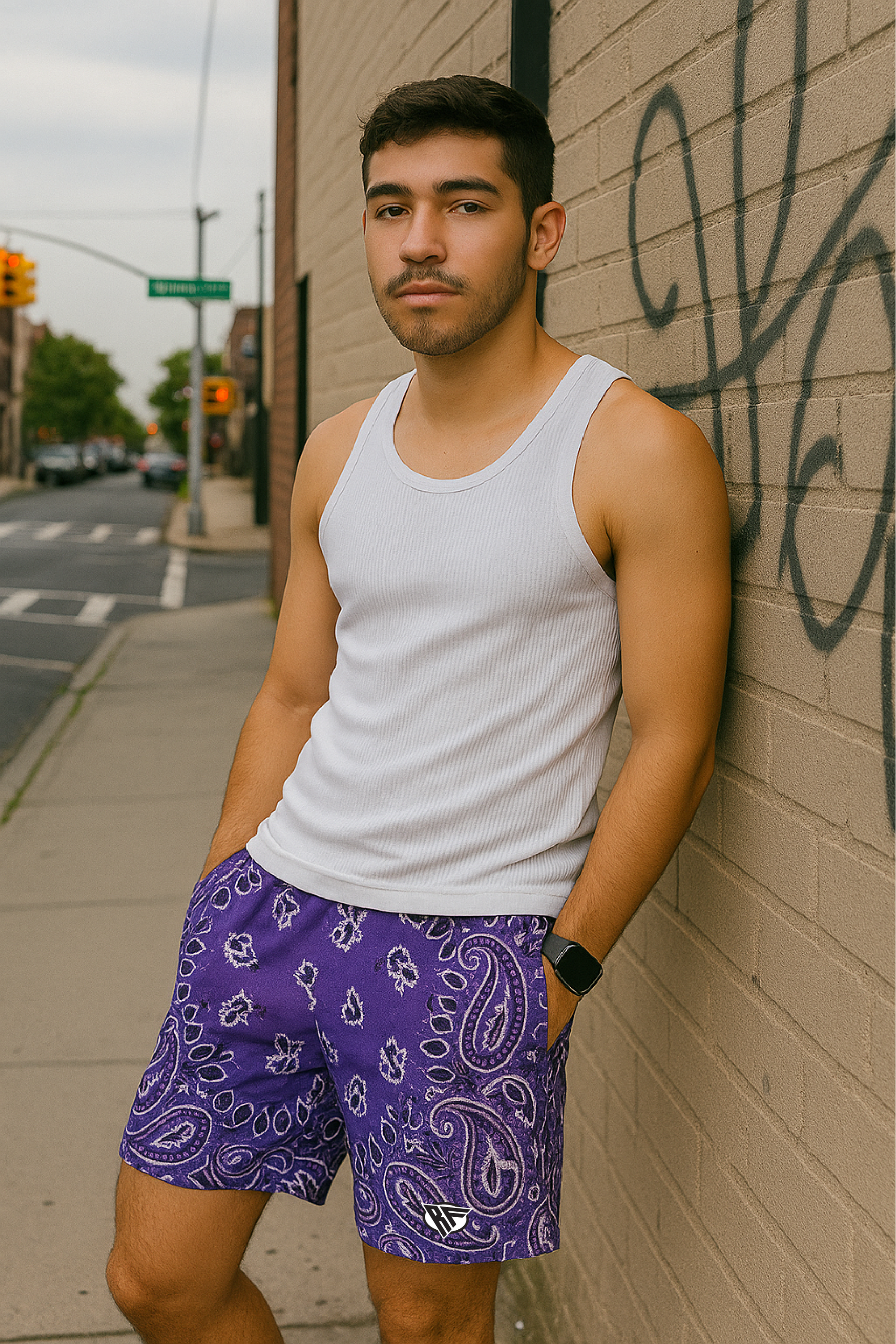 Man leaning against wall on city sidewalk wearing RF-Wear Men's Mesh Bandana Shorts in Purple. 