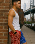 Man leaning against street wall wearing RF-Wear Men's Mesh Split Bandana Shorts - Red/Blue. 