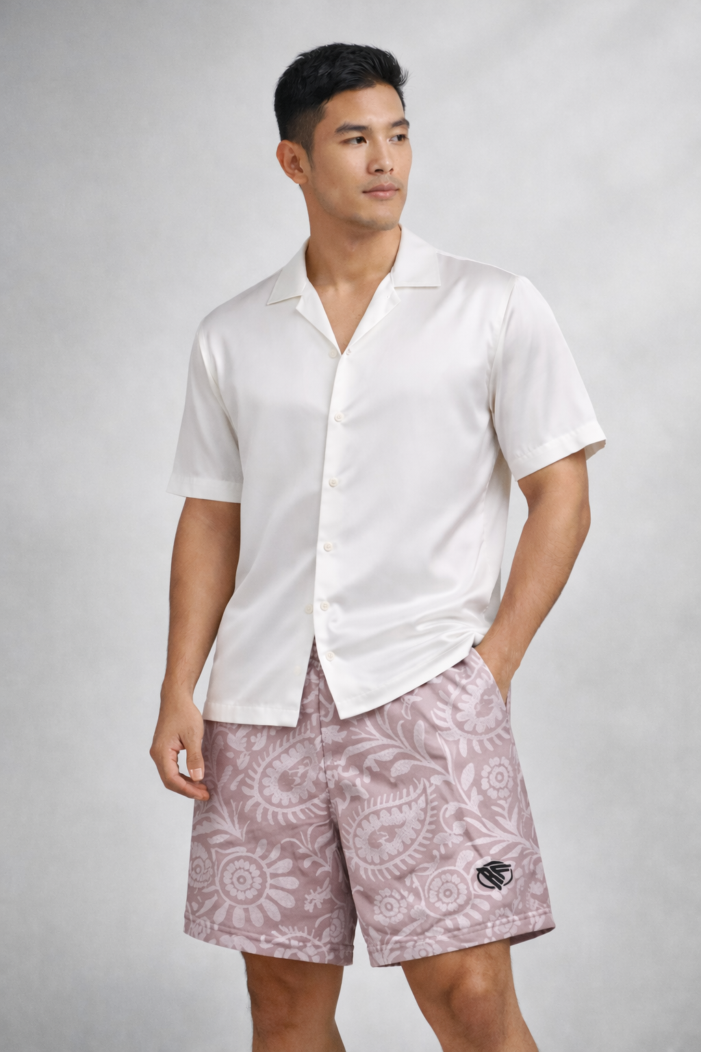 Man wearing a white silk top and RF-Wear Paisley Shorts in Mauve/White