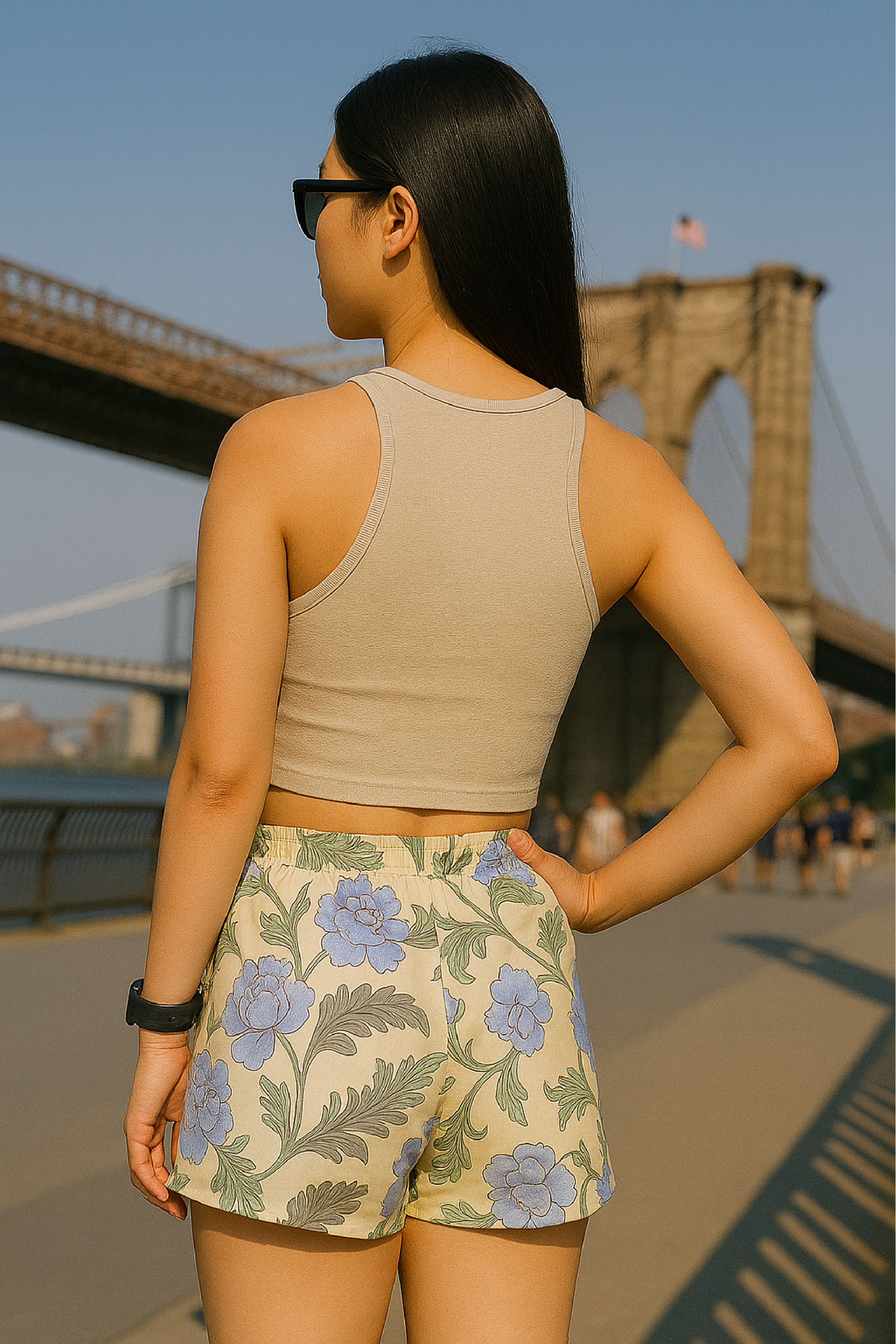 Woman wearing a cream crop top and RF-Wear women's carnation shorts in cream/blue with a bridge in the background