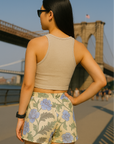 Woman wearing a cream crop top and RF-Wear women's carnation shorts in cream/blue with a bridge in the background
