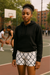 Person wearing a black hoodie and white shorts with black chain link pattern on a basketball court.