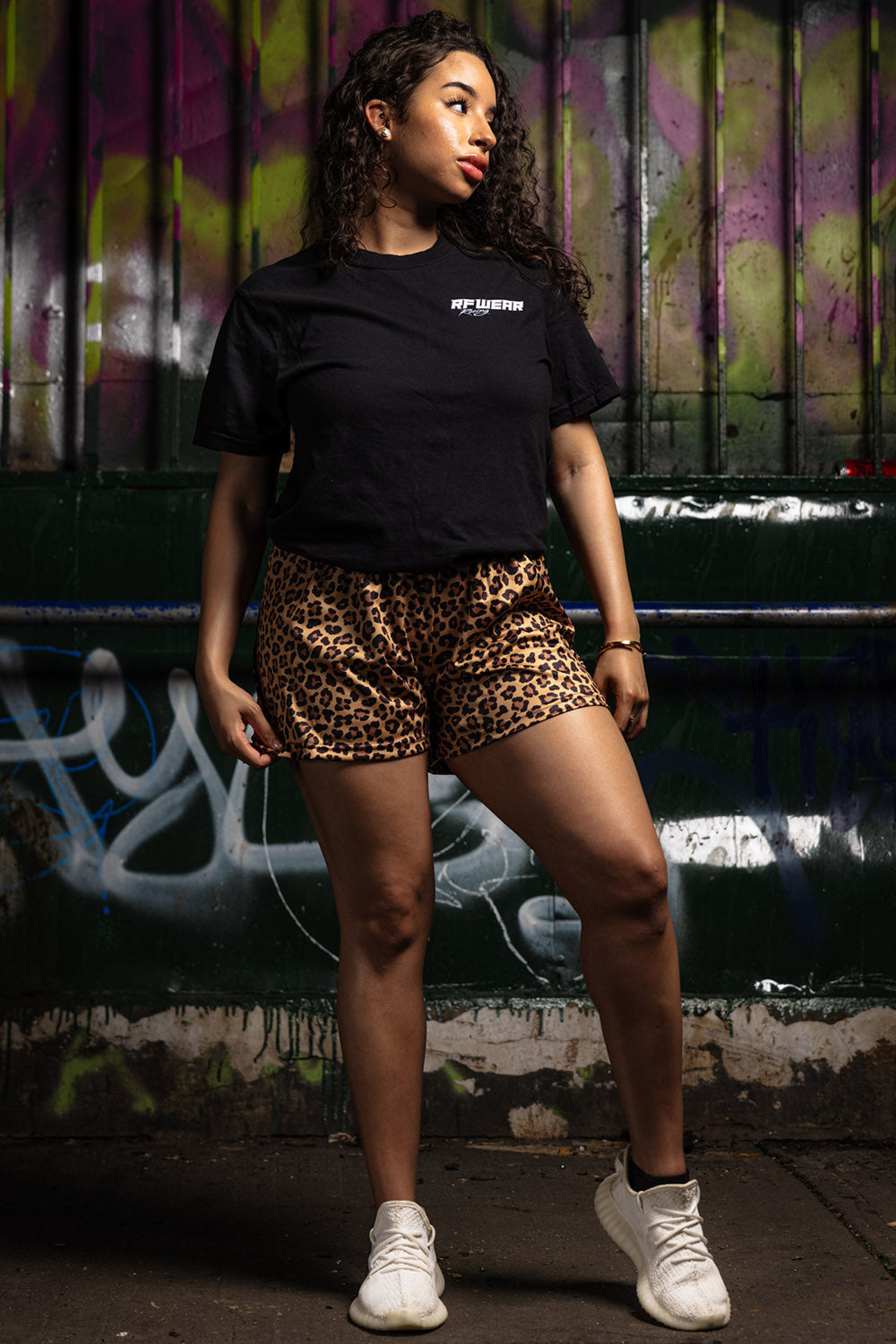 Woman wearing a black t-shirt and RF-Wear Women's Animal Print Shorts - Cheetah in Brown