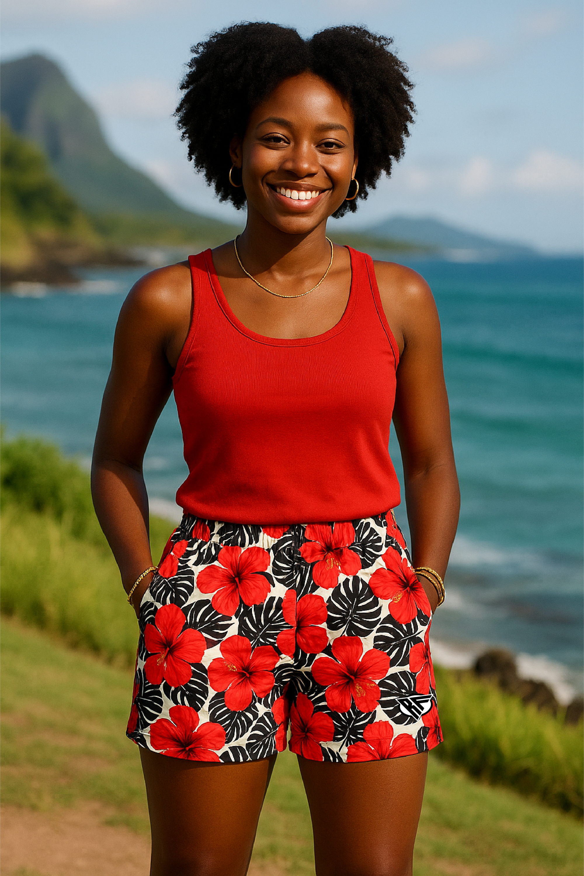 Woman in a red top and floral shorts standing in front of a scenic ocean view.