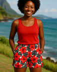 Woman in a red top and floral shorts standing in front of a scenic ocean view.