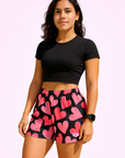Woman wearing a black top and RF-Wear Women's Heart Shorts in Black/Pink