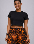 Woman wearing a black cropped top and RF-Wear Women's Hot Lava Shorts in Black/Orange