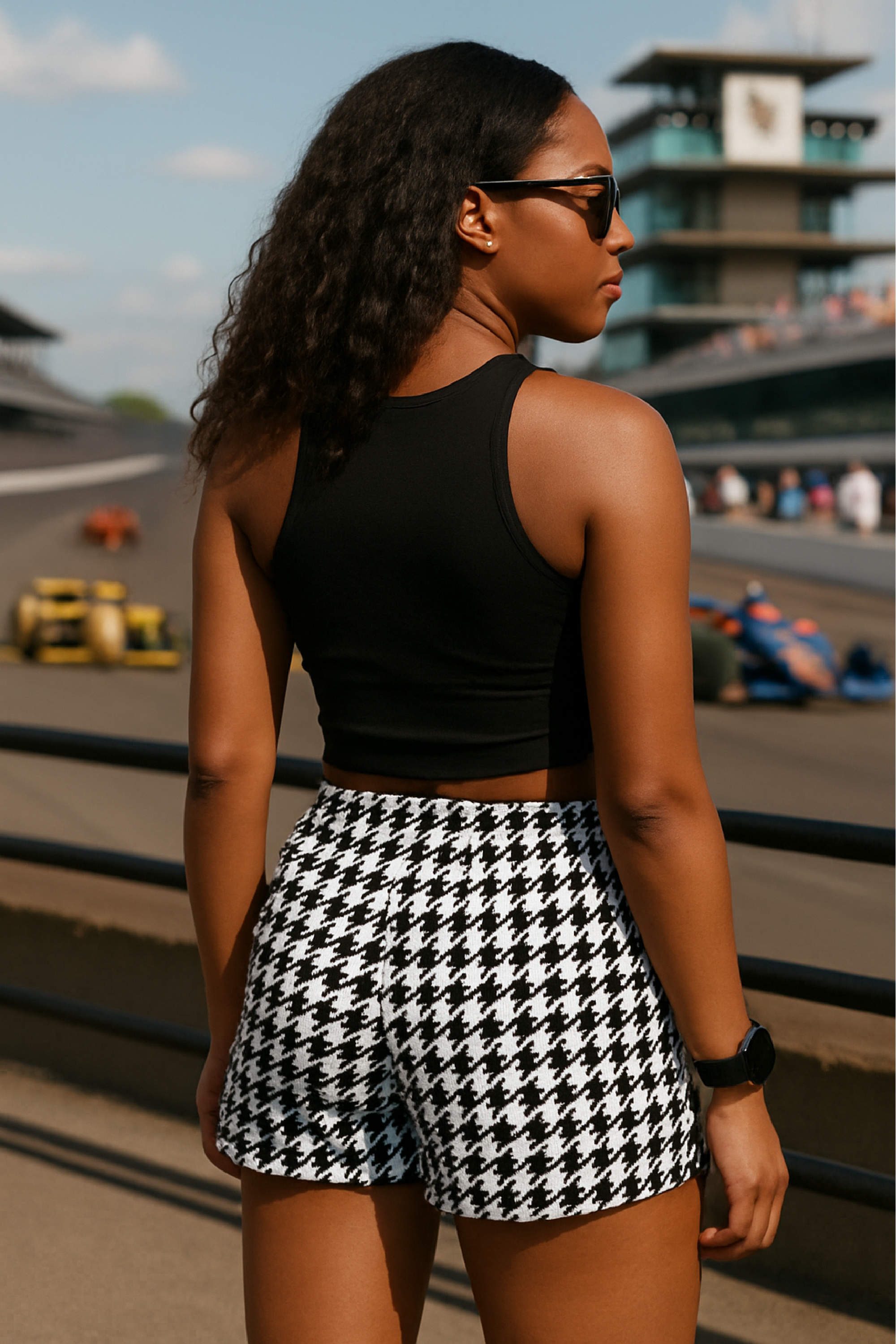 Woman at race track wearing a black crop top and RF-Wear Women's Houndstooth Shorts - Black/White  - Back View