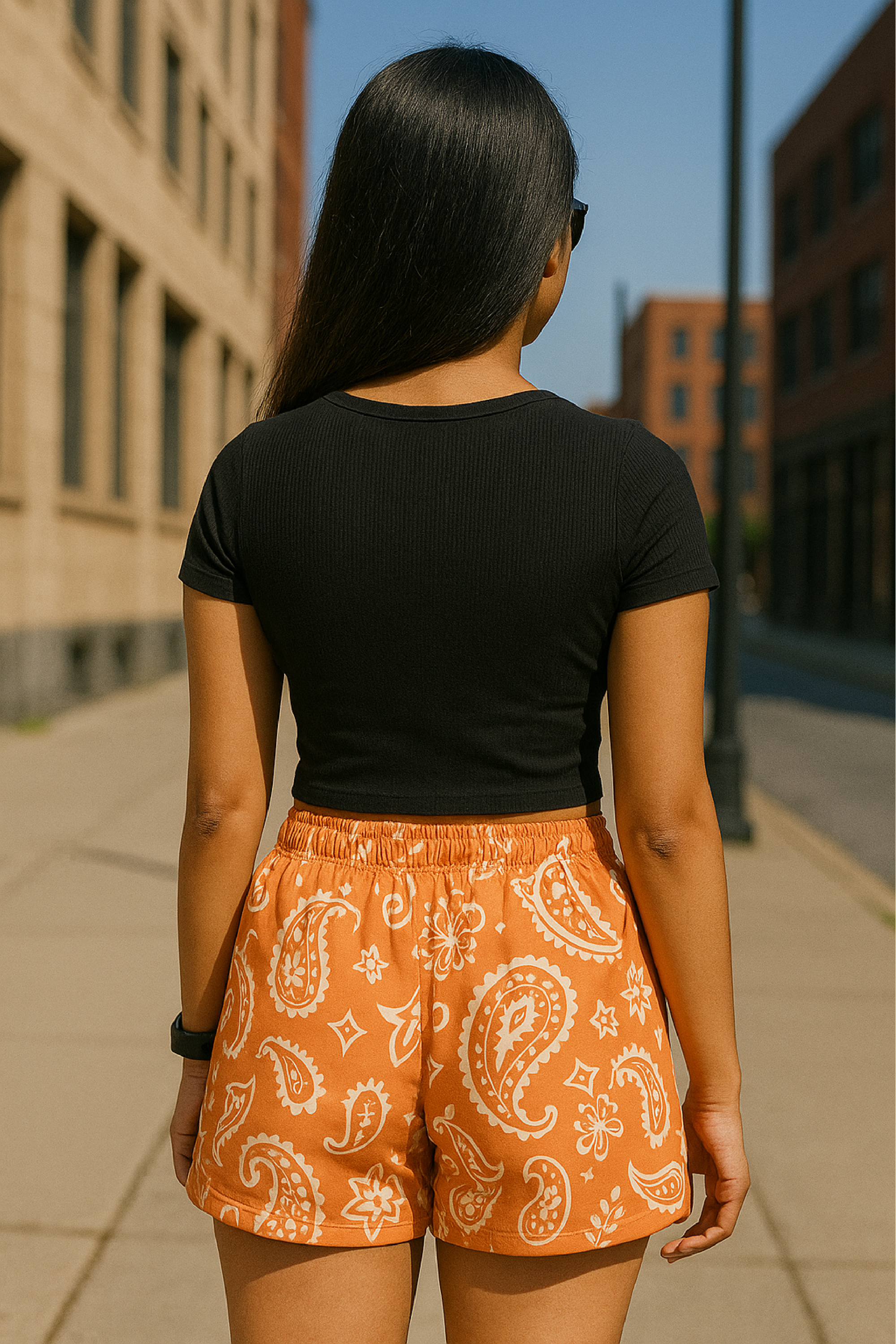 Woman standing in city wearing RF-Wear Women's Paisley Shorts - Apricot/Cream - Back View