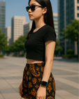 Woman in the city wearing RF-Wear Women's Paisley Shorts - Black/Orange - Side View