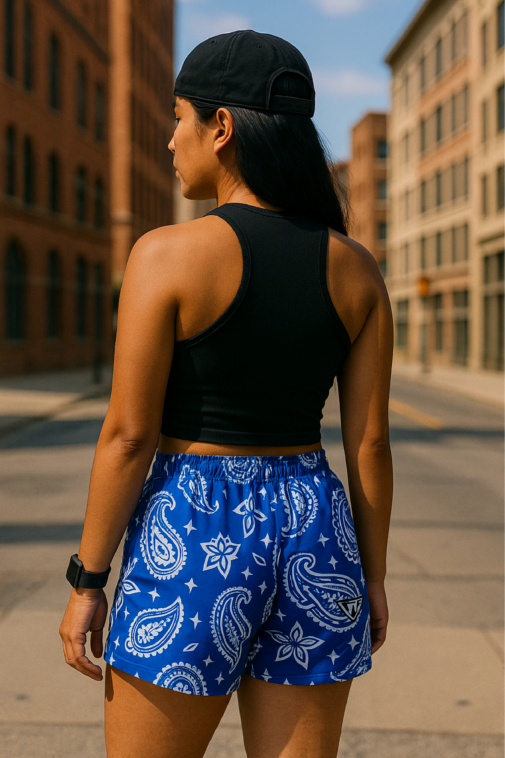 Woman standing on city street wearing RF-Wear Women's Paisley Shorts - Blue/White - Back View