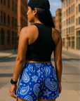 Woman standing on city street wearing RF-Wear Women's Paisley Shorts - Blue/White - Back View