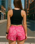 Woman standing in the city wearing RF-Wear Women's Paisley Shorts - Fuchsia/White - Back View