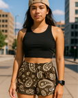 Woman standing on city sidewalk wearing RF-Wear Women's Paisley Shorts - Mocha/Cream - Front View