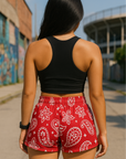 Woman standing near buildings wearing RF-Wear Women's Paisley Shorts - Red/White - Back View