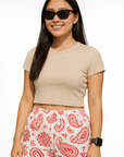 Woman wearing a beige crop top and RF-Wear Women's Paisley Shorts in White/Red