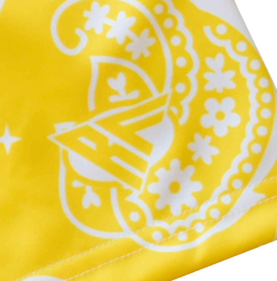 Close-up of women's paisley shorts in yellow/white with brand logo