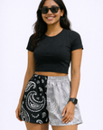 Woman wearing a black top and RF-Wear Women's Split Paisley Shorts in Black/Silver
