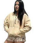 Woman wearing a cream RF-Wear Hoodie with RF-Wear women's porcelain shots in Rose Cream.