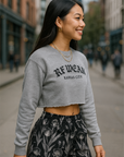 Woman wearing a gray sweatshirt with 'RF-WEAR' branding and RF-Wear women's black/grey  porcelains shorts on a city street.