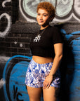 Woman standing next to graffiti wall wearing a black top and RF-Wear Women's  Porcelain Shorts - White/Blue