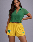 Woman wearing a green top and RF-Wear Women's Shamrock Shorts in Gold