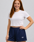 Woman wearing a white top and RF-Wear Women's Solid Color Shorts in Navy