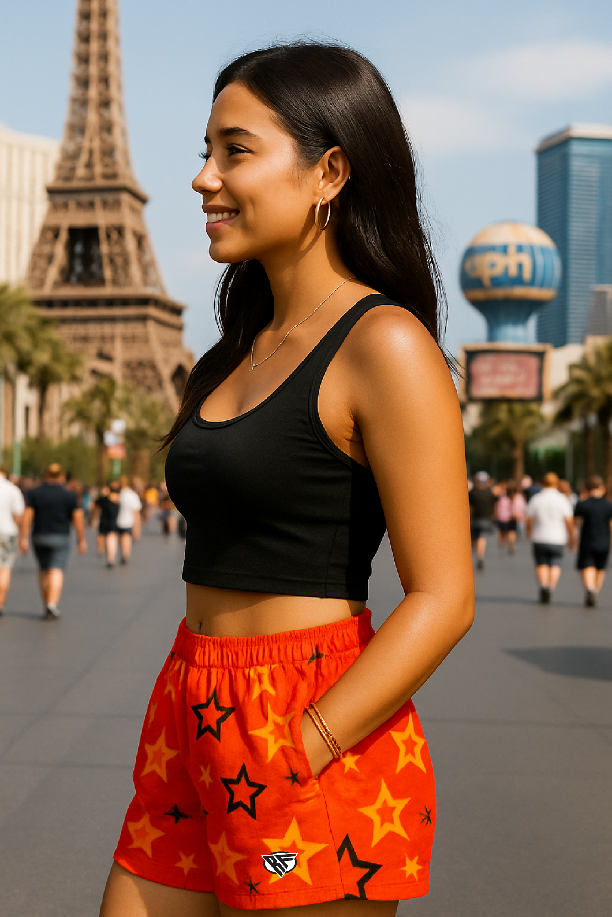 Woman in black crop top and red shorts with star patterns standing on Vegas Strip. 