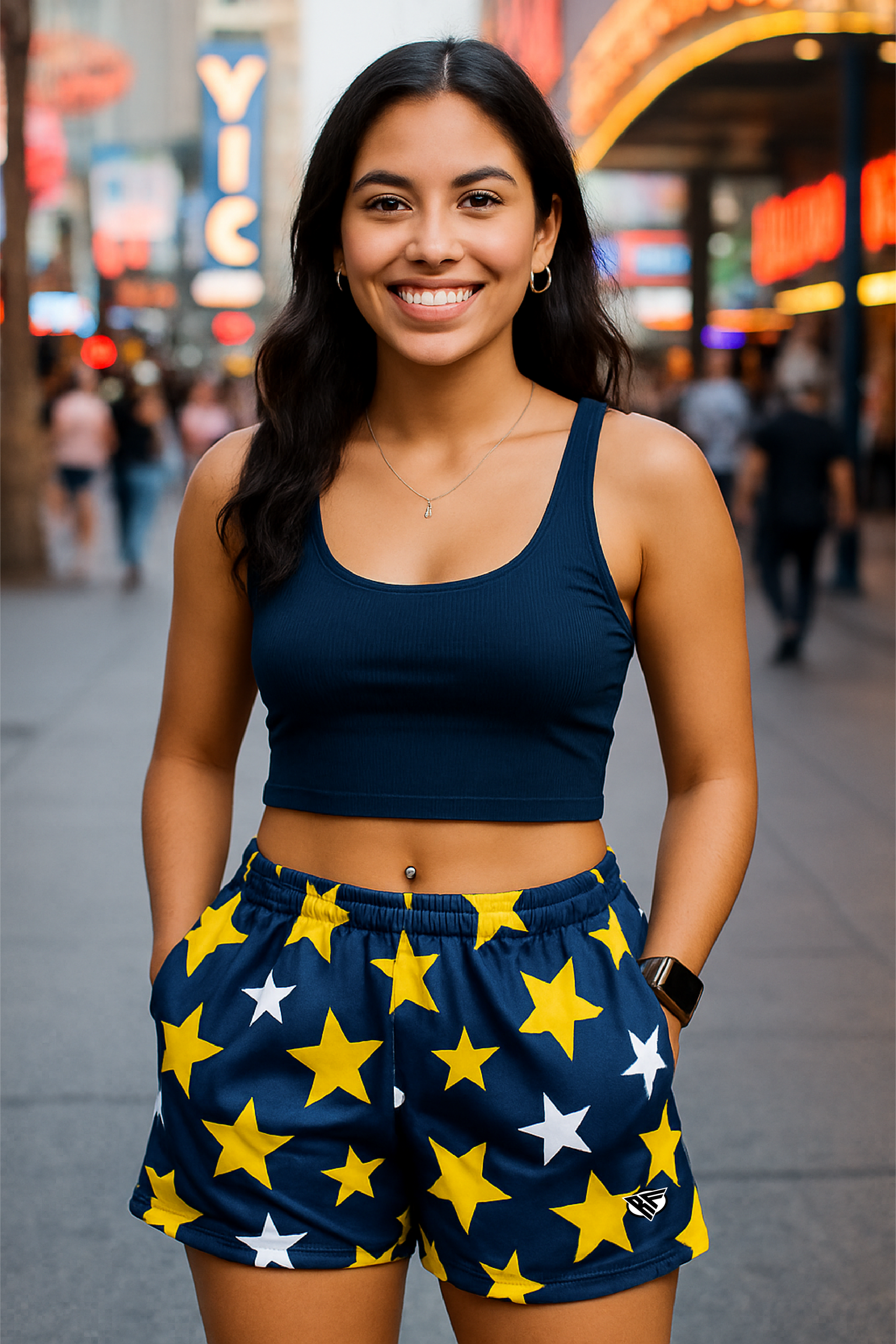 Woman wearing a navy blue crop top and star-patterned shorts in a city street setting.
