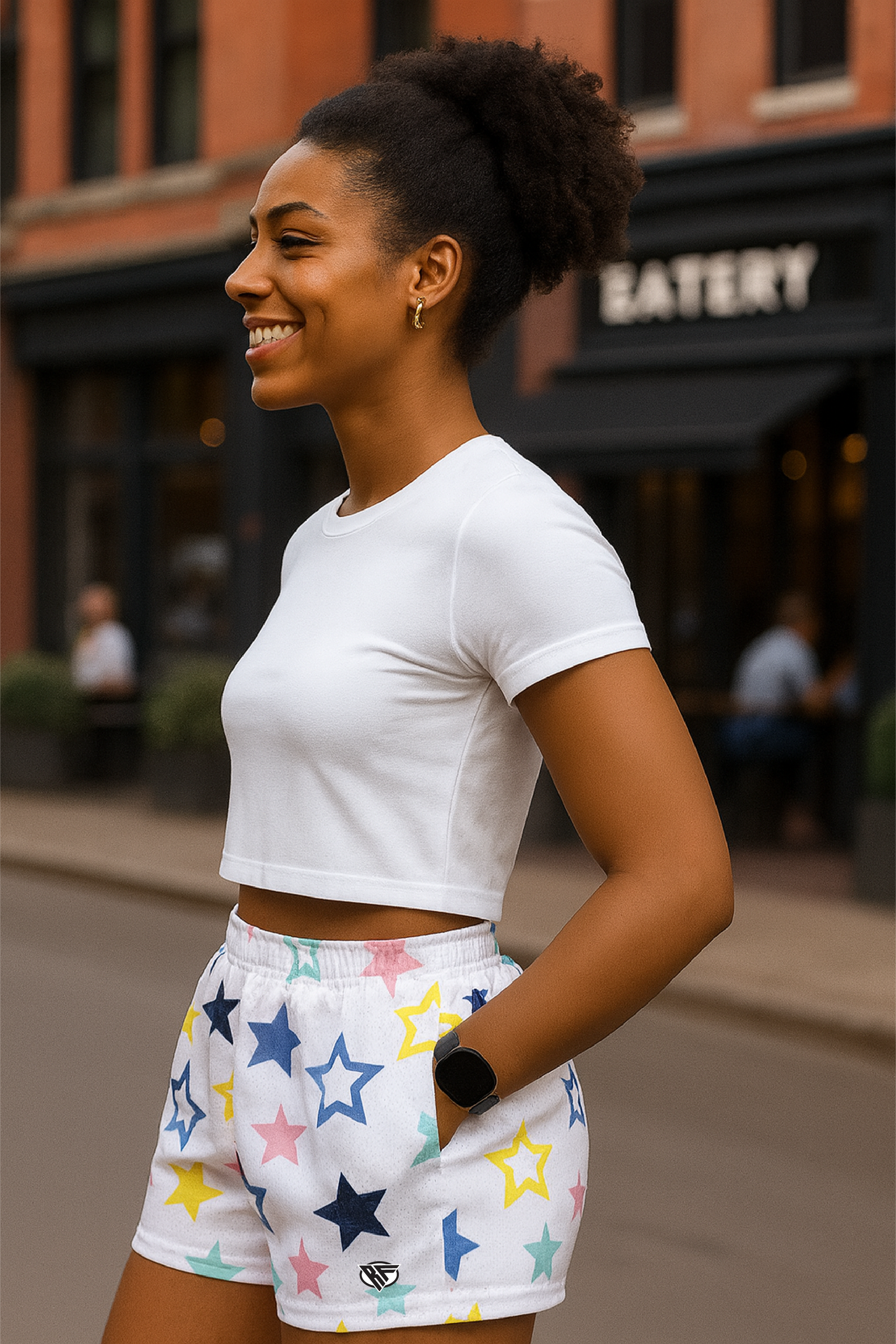 Woman wearing a white crop top and star-patterned shorts on a city street.