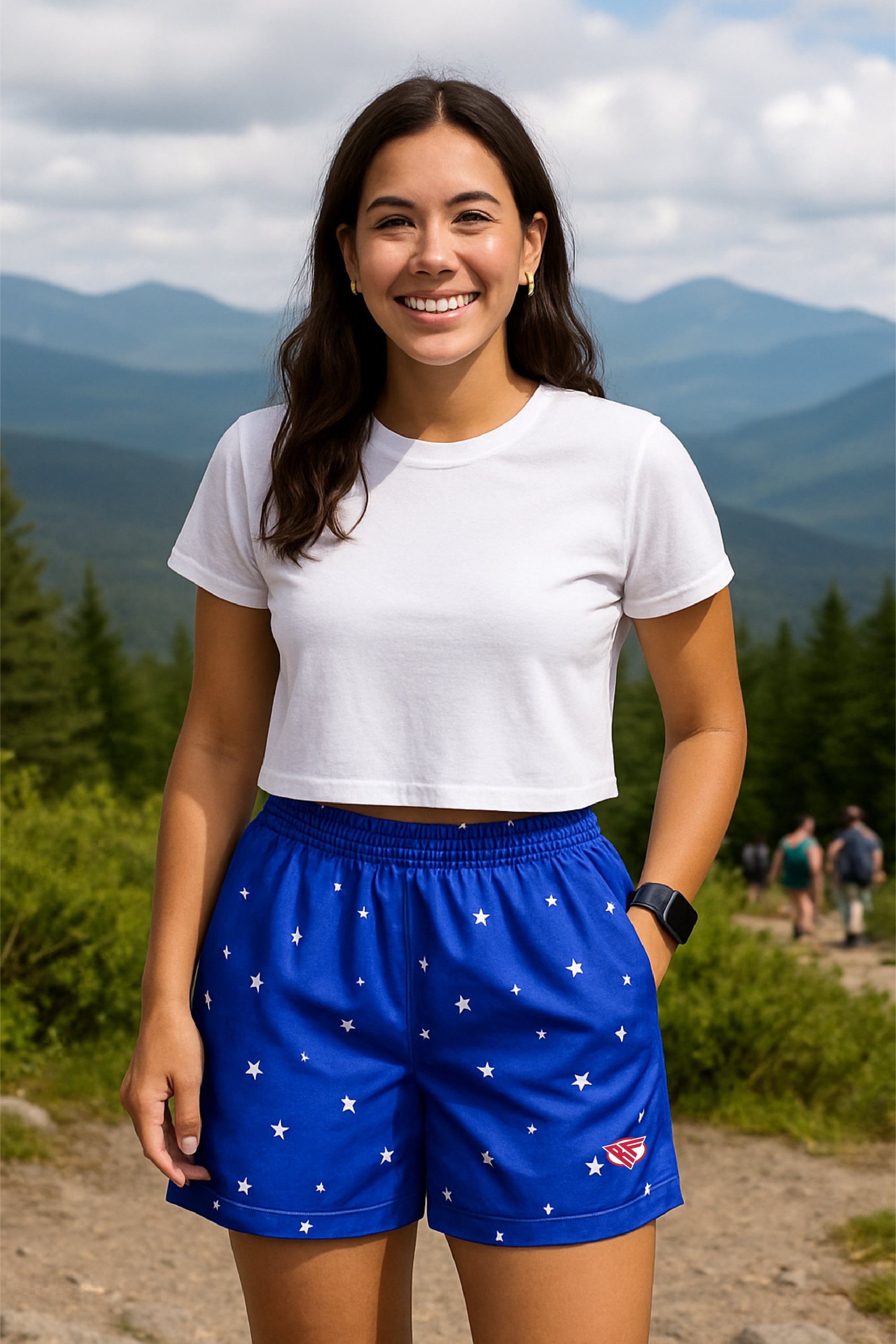 Woman wearing a white t-shirt and blue shorts with star pattern in a mountainous area