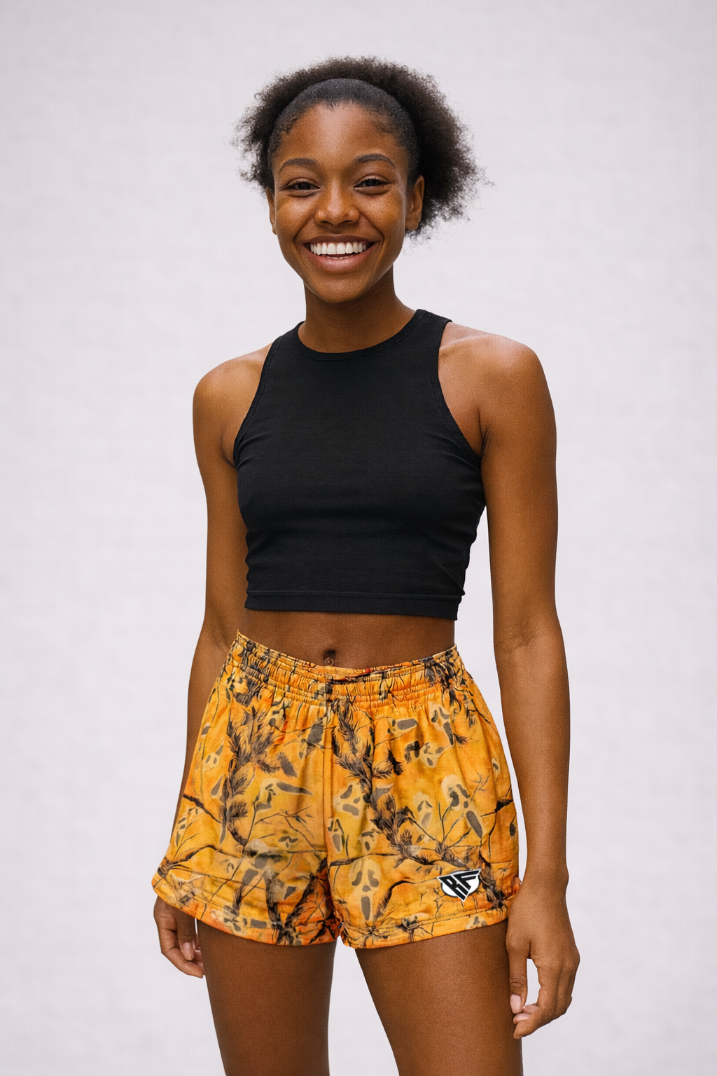 Woman wearing RF-Wear Women's Tree-Camo Ghost Faces Shorts in Orange