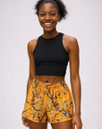 Woman wearing RF-Wear Women's Tree-Camo Ghost Faces Shorts in Orange
