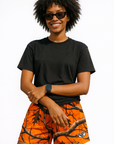 Woman wearing a black top and RF-Wear Women's Tree Camo Shorts in Orange 