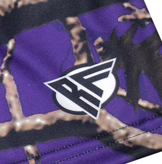 Close-up of a brand logo on a purple tree camo shorts