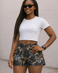 Woman wearing a white top and RF-Wear Womens Tree Camo Shorts in Storm