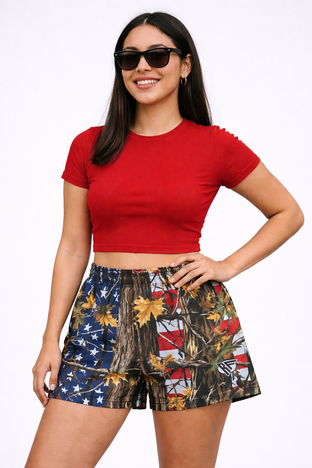 Woman wearing a red top and RF-Wear Women's Tree Camo Shorts - USA Flag 