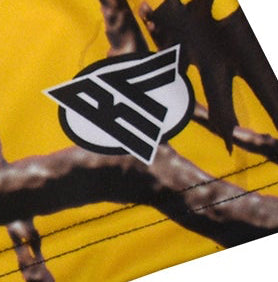 Close-up women's tree camo shorts in yellow with Brand Logo