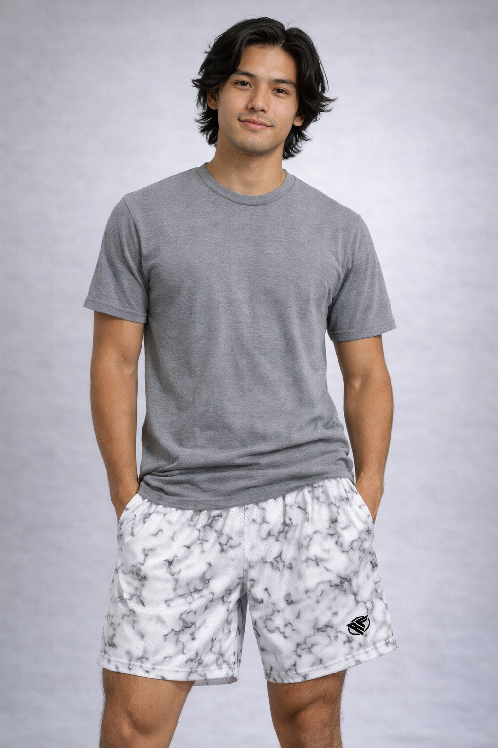Man wearing a grey t-shirt and RF-Wear Men's Mesh Marble Shorts in Black/White