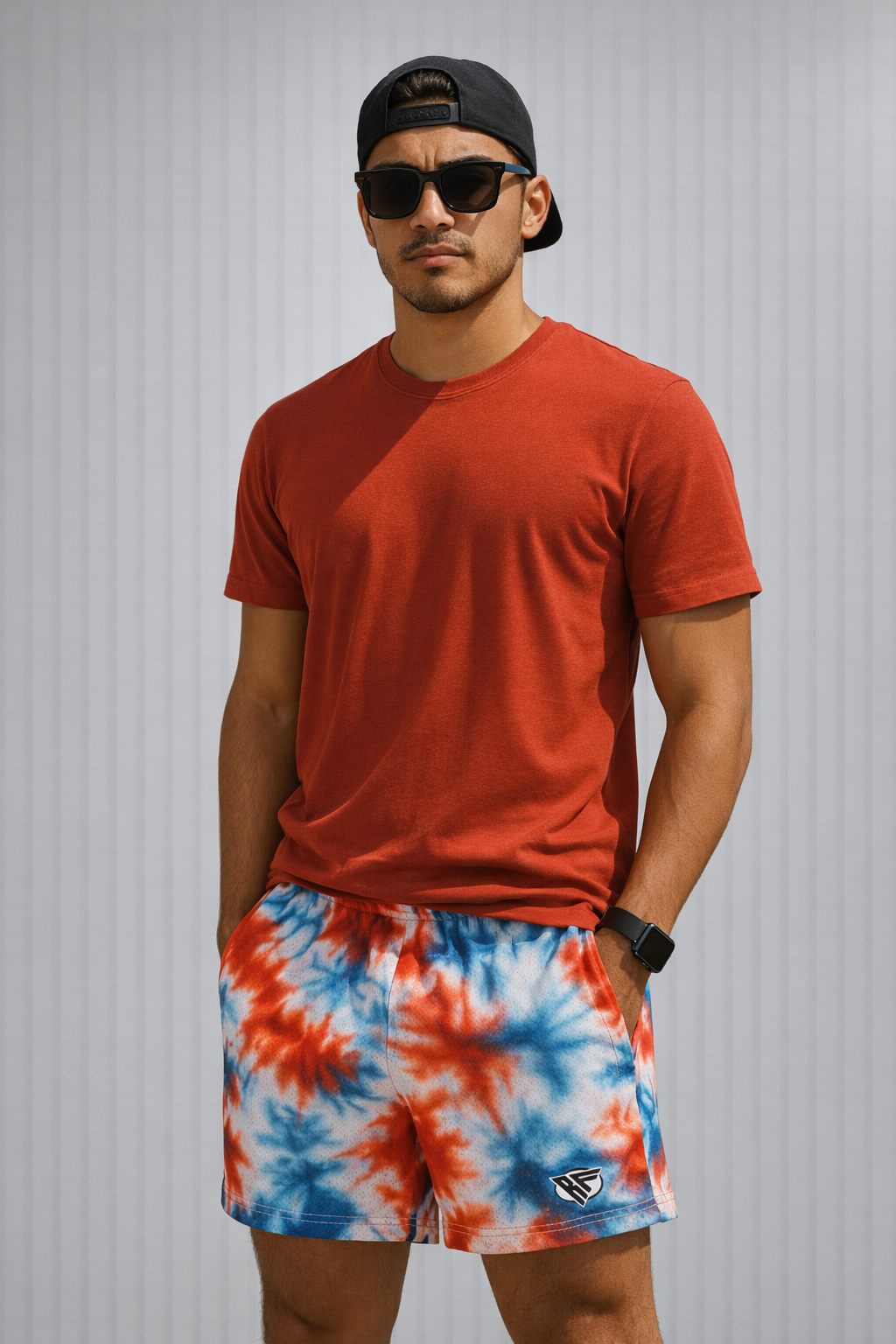 Man wearing a red t-shirt, hat, and RF-Wear Men's Mesh Patriotic Tie Dye Shorts in Red/White/Blue